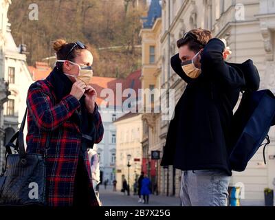 Ljubljana, Slovénie; 12.03.2020. Couple et amis portant un masque de protection du visage régulier, depuis l'apparition du nouveau coronavirus SRAS-CoV-2 et d'une grippe. Banque D'Images