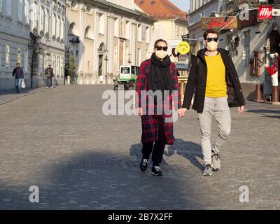 Ljubljana, Slovénie; 12.03.2020. Couple et amis portant un masque de protection du visage régulier, depuis l'apparition du nouveau coronavirus SRAS-CoV-2 et d'une grippe. Banque D'Images