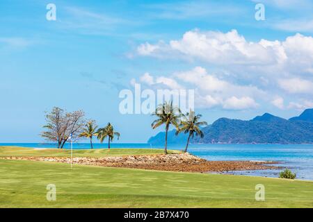 Vue sur les 8 et 16 greens d'entraînement de la mer d'Andaman et de l'île Anak Datai au parcours de golf Rainforest, au Els Club, Langkawi Banque D'Images