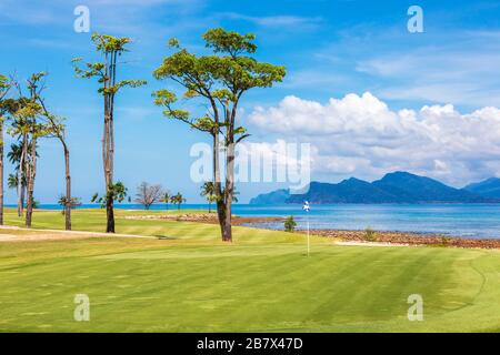 Vue sur le 8ème green d'entrée à la mer d'Andaman et l'île d'Anak Dai au parcours de golf Rainforest, au Club d'Els, à Teluk Dai, Langkawi, Banque D'Images