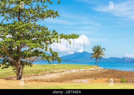 Vue sur le 16ème green de mise à la mer d'Andaman et l'île d'Anak Datai au parcours de golf Rainforest, le Club d'Els, Teluk Datai, Langkawi, Banque D'Images