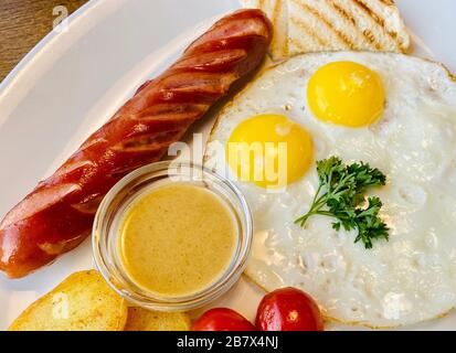 œufs frits avec saucisses et toasts sur une plaque. Bon petit déjeuner Banque D'Images