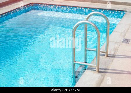 Escalier métallique pour la piscine. Piscine de l'hôtel. Espace de copie Banque D'Images
