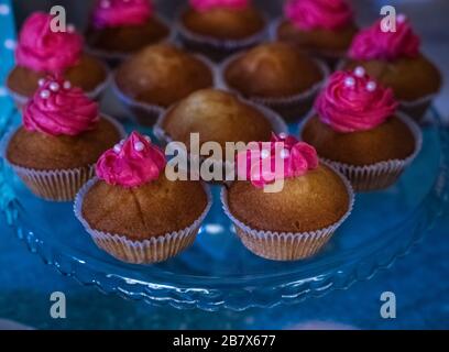 Délicieux cupcakes avec crème rose et décoration sur la table festive, vue sur le dessus Banque D'Images
