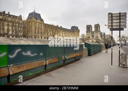 Paris - 17 mars 2020: Jogger devant des magasins de livres fermés dans le quartier latin très calme en raison de l'arrêt ordonné. Banque D'Images