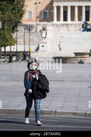 Athènes, Grèce. 18 mars 2020. Une femme, portant un masque de protection, marche dans les vides de la place principale Syntagma à Athènes, Grèce. Le gouvernement grec a donné des instructions aux citoyens de rester chez eux pour prévenir la propagation de la maladie du coronavirus du Covid-19. ©Elias Verdi/Alay Live News Banque D'Images
