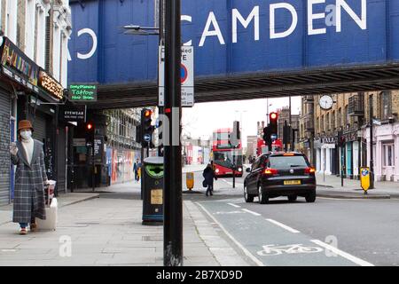 Une femme avec un masque marche à travers le marché de Camden mercredi 18 mars 2020, comme la propagation du Coronavirus (COVID-19) effets Londres Banque D'Images