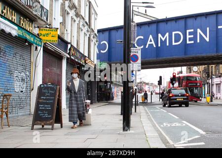 Une femme avec un masque marche à travers le marché de Camden mercredi 18 mars 2020, comme la propagation du Coronavirus (COVID-19) effets Londres Banque D'Images