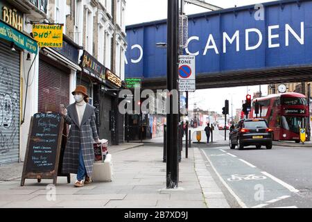 Une femme avec un masque marche à travers le marché de Camden mercredi 18 mars 2020, comme la propagation du Coronavirus (COVID-19) effets Londres Banque D'Images