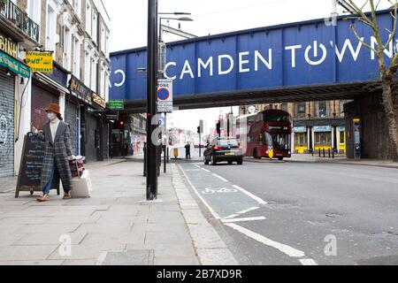 Une femme avec un masque marche à travers le marché de Camden mercredi 18 mars 2020, comme la propagation du Coronavirus (COVID-19) effets Londres Banque D'Images