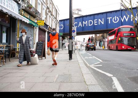 Une femme avec un masque marche à travers le marché de Camden mercredi 18 mars 2020, comme la propagation du Coronavirus (COVID-19) effets Londres Banque D'Images