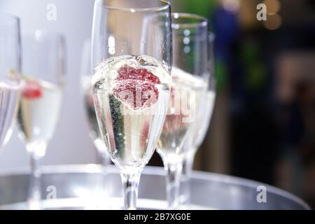 Plateau de service avec verres de champagne à la framboise en gros plan à l'événement. Banque D'Images