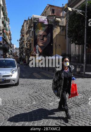 Naples, Italie. 18 mars 2020. Une femme portant un masque de protection marche dans le centre de la ville de Naples, après un décret du gouvernement déclarant à toute l'Italie une zone protégée pour lutter contre l'infection du coronavirus covid-19. Crédit: Independent photo Agency SRL/Alay Live News Banque D'Images