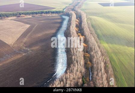Paysage de la terre ukrainienne - un champ, une déteste des arbres, neige sur terre noire. Belle vue de la drone. Beau paysage. Réunion de trois mers Banque D'Images