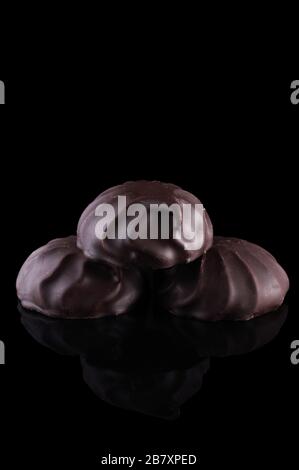 Une bande de guimauves au chocolat sur fond noir. Isoler marshmallow. Cadre vertical. Banque D'Images