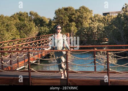 Les femmes touristes apprécient le coucher du soleil au parc de bord de mer de Mangrove Walk à Abu Dhabi, aux Emirats Arabes Unis Banque D'Images