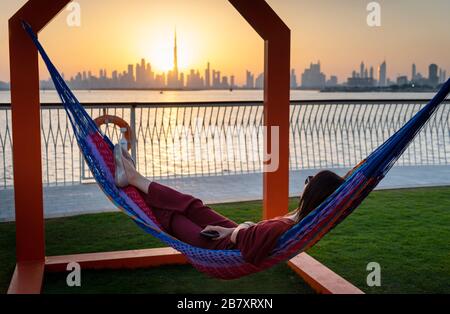 Femme bénéficiant d'une vue magnifique sur le coucher du soleil de Dubaï depuis le port de creek Banque D'Images