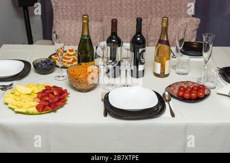 Vue rapprochée de la table servie avec un chiffon blanc. Fruits et légumes colorés, salades et en-cas. Bouteilles sans alcool. Banque D'Images