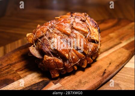 porc rôti isolé sur planche en bois à la table de cuisine maison Banque D'Images