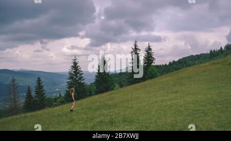 Une jeune fille sur une pente de montagne dans Carpates a l'air à l'avance Banque D'Images