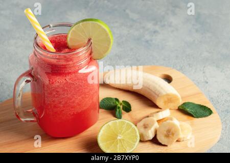 Smoothie au melon d'eau avec banane, citron vert et menthe dans un bol à tasse sur un tableau de découpe. Concept de saine alimentation. Banque D'Images