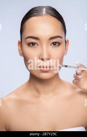 La jolie femme asiatique est en train de faire une injection Banque D'Images