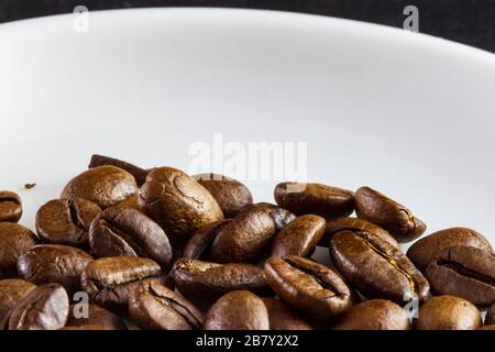 Capture macro de grains de café dans une tasse de café blanche Banque D'Images