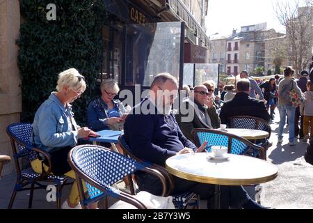 Café-bar à Pezenas, dans le sud de la France, le jour du marché. Marchés français gens occupés foules ville animée europe style de vie européen communauté socialisante Banque D'Images