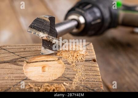 Forage en bois brut. Foret pour grands trous. Lieu - atelier de menuiserie. Banque D'Images