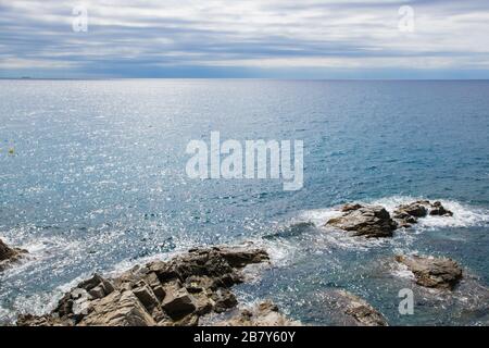 Belle vue sur les vagues de la mer, les rochers, les pierres et les nuages dans le ciel. Espagne. Banque D'Images