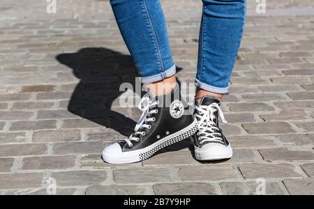 Chartres, France - 2 septembre 2019 : Droit de la partie inférieure de l'adolescent, les jambes en jeans et baskets Converse All Star dans une rue pavée. Banque D'Images