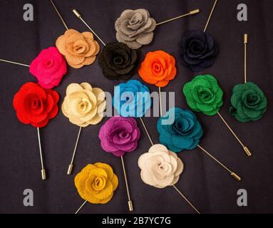 Broches roses colorées sur un tissu gris Banque D'Images