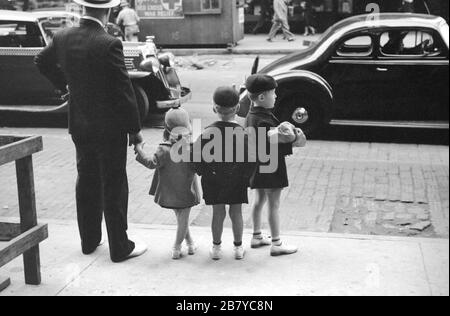 Père et trois enfants qui attendent de traverser la rue, Chicago, Illinois, États-Unis, John Vachon, pour la U.S. Farm Security Administration, juillet 1940 Banque D'Images