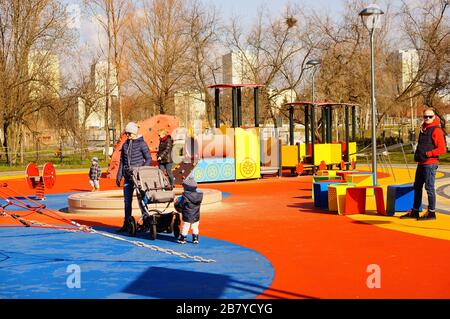 POZNAN, POLOGNE - 08 mars 2020: Parents et enfants sur une aire de jeux colorée avec différents équipements sur le parc Rataje. Banque D'Images