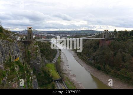 Pont suspendu Clifton de Brunel en journée nuageux à marée basse, Clifton, Bristol, Royaume-Uni, avec le refuge de roche de galerie au-dessus de la route de Portway en contrebas Banque D'Images