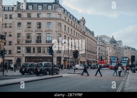 Londres, Royaume-Uni - 06 mars 2020 : taxis noirs, bus et gens sur Regent Street, une grande rue commerçante du West End de Londres, magasins en arrière-plan Banque D'Images
