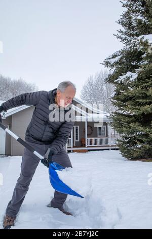 Homme senior qui pelle la neige Banque D'Images