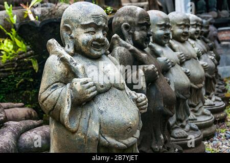 Une rangée de statues de moine gras dans une usine de sculpture de statue de Bali. Banque D'Images