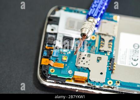 Technicien répare la carte principale micro-circuit de la technologie électronique du smartphone : ordinateur, matériel, téléphone mobile, mise à niveau, concept de nettoyage. Banque D'Images