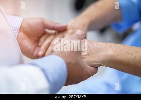 Médecin tenant les mains Asian senior ou âgée femme patiente avec amour, soins, encourager et empathie au service hospitalier : sain fort m Banque D'Images