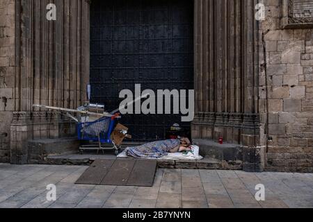 Barcelone, Espagne. 18 mars 2020. Un sans-abri est vu dormir à la porte de l'église de Santa Maria del Mar pendant la propagation du coronavirus.Barcelone fait face au quatrième jour de confinement à la maison et de distanciation sociale en raison de la propagation du coronavirus. Crédit: SOPA Images Limited/Alay Live News Banque D'Images