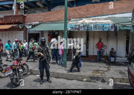 Caracas, Venezuela. 18 mars 2020. Un policier est vu en utilisant un mégaphone alertant les gens sur le coronavirus et leur dire de rentrer à la maison.après 3 jours de quarantaine décrétés par le gouvernement du président Nicolas Maduro, jusqu'à présent le chiffre de 36 personnes confirmées être infectées par COVID-19 reste. Les résultats sont attendus de plus de 120 échantillons envoyés par l'institut d'hygiène. Les agences de sécurité continuent de fermer les entreprises et d'essayer de garder les gens dans leur foyer pour empêcher le virus de se propager davantage. Crédit: SOPA Images Limited/Alay Live News Banque D'Images