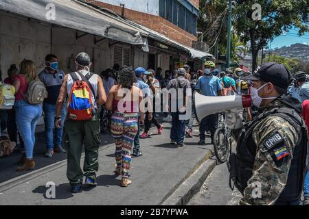 Caracas, Venezuela. 18 mars 2020. Un policier est vu en utilisant un mégaphone alertant les gens sur le coronavirus et leur dire de rentrer à la maison.après 3 jours de quarantaine décrétés par le gouvernement du président Nicolas Maduro, jusqu'à présent le chiffre de 36 personnes confirmées être infectées par COVID-19 reste. Les résultats sont attendus de plus de 120 échantillons envoyés par l'institut d'hygiène. Les agences de sécurité continuent de fermer les entreprises et d'essayer de garder les gens dans leur foyer pour empêcher le virus de se propager davantage. Crédit: SOPA Images Limited/Alay Live News Banque D'Images