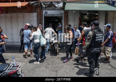 Caracas, Venezuela. 18 mars 2020. Un policier est vu en utilisant un mégaphone alertant les gens sur le coronavirus et leur dire de rentrer à la maison.après 3 jours de quarantaine décrétés par le gouvernement du président Nicolas Maduro, jusqu'à présent le chiffre de 36 personnes confirmées être infectées par COVID-19 reste. Les résultats sont attendus de plus de 120 échantillons envoyés par l'institut d'hygiène. Les agences de sécurité continuent de fermer les entreprises et d'essayer de garder les gens dans leur foyer pour empêcher le virus de se propager davantage. Crédit: SOPA Images Limited/Alay Live News Banque D'Images