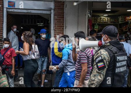 Caracas, Venezuela. 18 mars 2020. Un policier est vu en utilisant un mégaphone alertant les gens sur le coronavirus et leur dire de rentrer à la maison.après 3 jours de quarantaine décrétés par le gouvernement du président Nicolas Maduro, jusqu'à présent le chiffre de 36 personnes confirmées être infectées par COVID-19 reste. Les résultats sont attendus de plus de 120 échantillons envoyés par l'institut d'hygiène. Les agences de sécurité continuent de fermer les entreprises et d'essayer de garder les gens dans leur foyer pour empêcher le virus de se propager davantage. Crédit: SOPA Images Limited/Alay Live News Banque D'Images