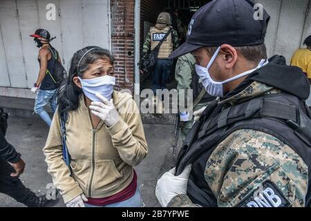 Caracas, Venezuela. 18 mars 2020. Le policier parle avec un civil de l'importance d'utiliser un facemask pendant la quarantaine.après 3 jours de quarantaine décrétés par le gouvernement du président Nicolas Maduro, jusqu'à présent le chiffre de 36 personnes confirmées être infectées par COVID-19 reste. Les résultats sont attendus de plus de 120 échantillons envoyés par l'institut d'hygiène. Les agences de sécurité continuent de fermer les entreprises et d'essayer de garder les gens dans leur foyer pour empêcher le virus de se propager davantage. Crédit: SOPA Images Limited/Alay Live News Banque D'Images