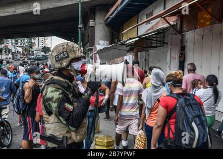 Caracas, Venezuela. 18 mars 2020. Un policier est vu en utilisant un mégaphone alertant les gens sur le coronavirus et leur dire de rentrer à la maison.après 3 jours de quarantaine décrétés par le gouvernement du président Nicolas Maduro, jusqu'à présent le chiffre de 36 personnes confirmées être infectées par COVID-19 reste. Les résultats sont attendus de plus de 120 échantillons envoyés par l'institut d'hygiène. Les agences de sécurité continuent de fermer les entreprises et d'essayer de garder les gens dans leur foyer pour empêcher le virus de se propager davantage. Crédit: SOPA Images Limited/Alay Live News Banque D'Images