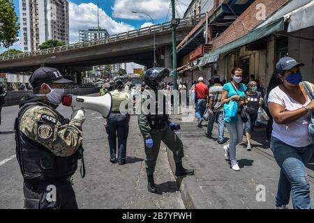 Caracas, Venezuela. 18 mars 2020. Un policier est vu en utilisant un mégaphone alertant les gens sur le coronavirus et leur dire de rentrer à la maison.après 3 jours de quarantaine décrétés par le gouvernement du président Nicolas Maduro, jusqu'à présent le chiffre de 36 personnes confirmées être infectées par COVID-19 reste. Les résultats sont attendus de plus de 120 échantillons envoyés par l'institut d'hygiène. Les agences de sécurité continuent de fermer les entreprises et d'essayer de garder les gens dans leur foyer pour empêcher le virus de se propager davantage. Crédit: SOPA Images Limited/Alay Live News Banque D'Images