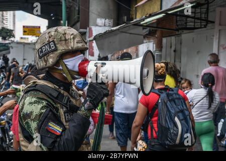 Caracas, Venezuela. 18 mars 2020. Un policier est vu en utilisant un mégaphone alertant les gens sur le coronavirus et leur dire de rentrer à la maison.après 3 jours de quarantaine décrétés par le gouvernement du président Nicolas Maduro, jusqu'à présent le chiffre de 36 personnes confirmées être infectées par COVID-19 reste. Les résultats sont attendus de plus de 120 échantillons envoyés par l'institut d'hygiène. Les agences de sécurité continuent de fermer les entreprises et d'essayer de garder les gens dans leur foyer pour empêcher le virus de se propager davantage. Crédit: SOPA Images Limited/Alay Live News Banque D'Images