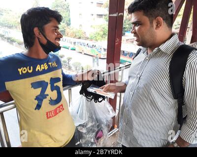 Un client négociant avec un fauteur de masque à au revoir masque de lui à Banani, Dhaka. En raison du virus Corona, la demande de masque est à la demande la plus forte maintenant. Banque D'Images